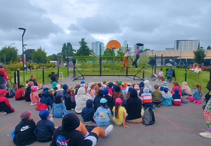 Groupe de jeunes réuni autour d'un spectacle organisé par le secteur anim2rue dans un city stade dans le quartier du Beau Marais