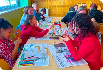 Groupe de famille faisant la décoration de coquetier réuni par le secteur Famille du centre social