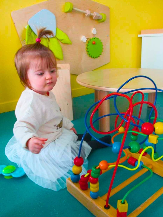 Petite fille qui joue à la crèche le manèges enchantés de l'Association Matisse