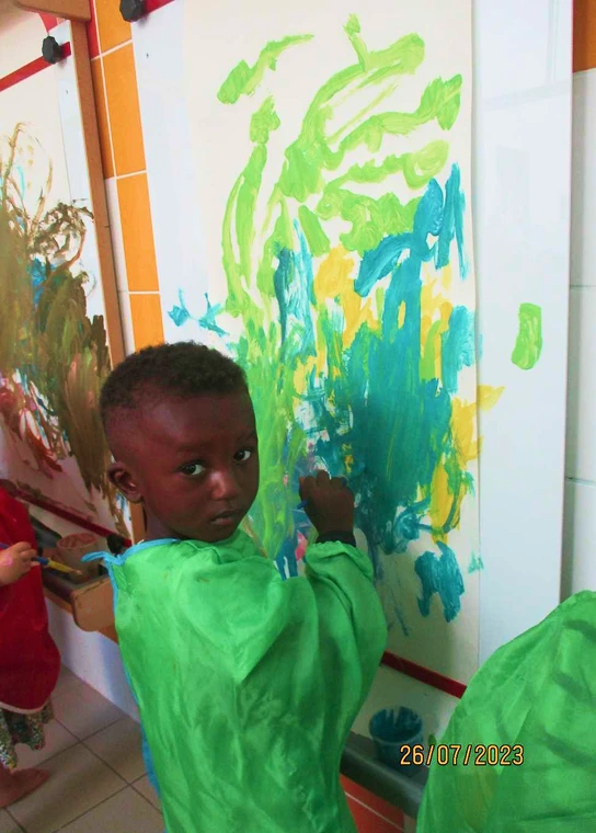 Petit garçon qui fait de la peinture à la crèche le manèges enchantés de l'Association Matisse